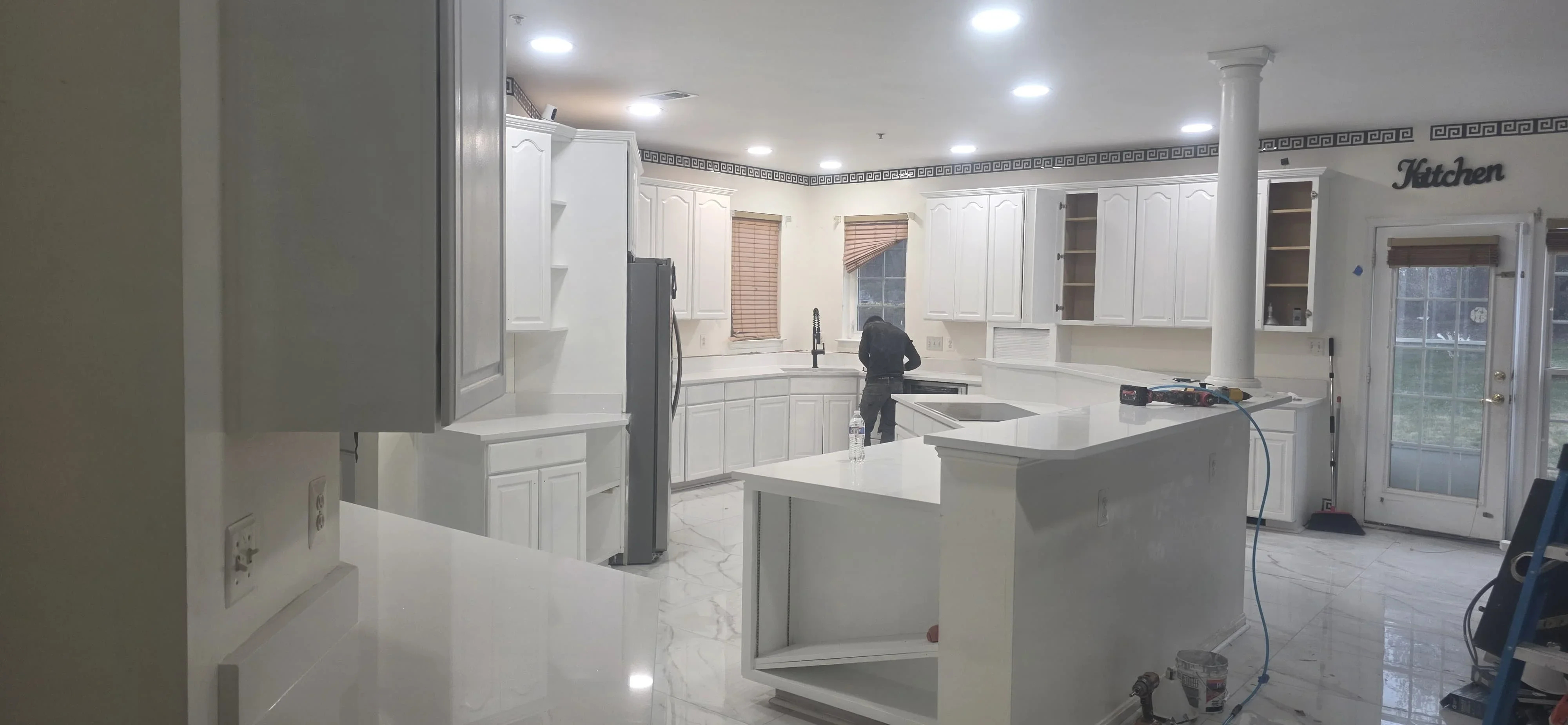 Modern kitchen with white cabinetry, quartz countertops, center island, and recessed lighting